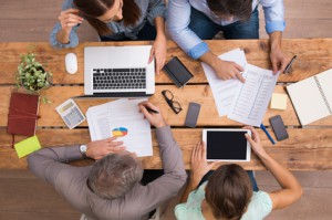 High angle view of businesspeople analyzing schemes and diagrams. Business team analyze growth and past history of company. Businesspeople in meeting discussing future prospects and growth strategies in office.